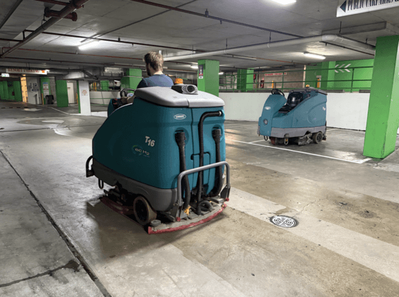 Ride-on floor scrubbers cleaning a car park